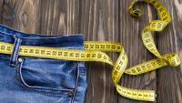 pair of blue jeans with tape measure as a belt